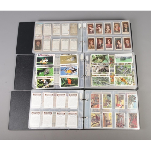 47 - Three albums of part sets of Cigarette and collectors cards, surrounding the themes of Royalty, Mili... 