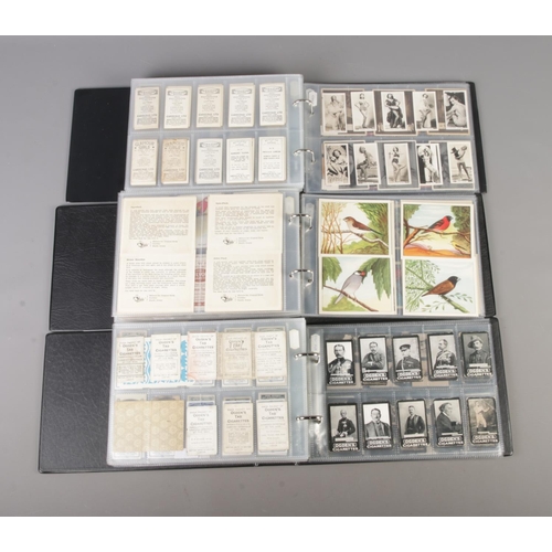 47 - Three albums of part sets of Cigarette and collectors cards, surrounding the themes of Royalty, Mili... 