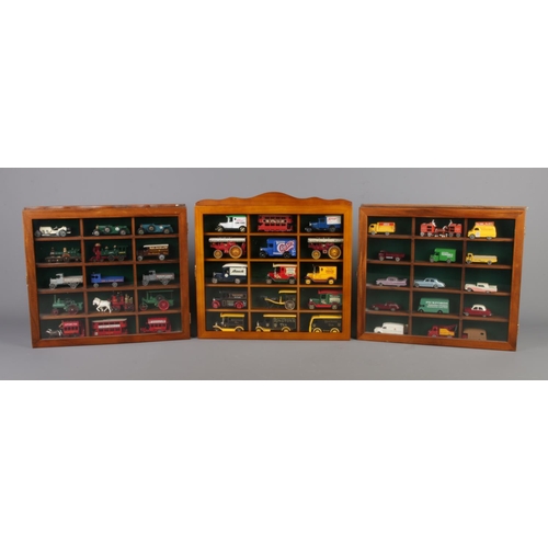 51 - Three display cabinets with glazed fronts housing model die-cast vehicles. Includes examples from Le... 