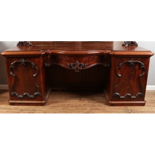 554 - A Victorian mahogany breakfront mirror back sideboard, with central pull out drawer flanked by two c... 