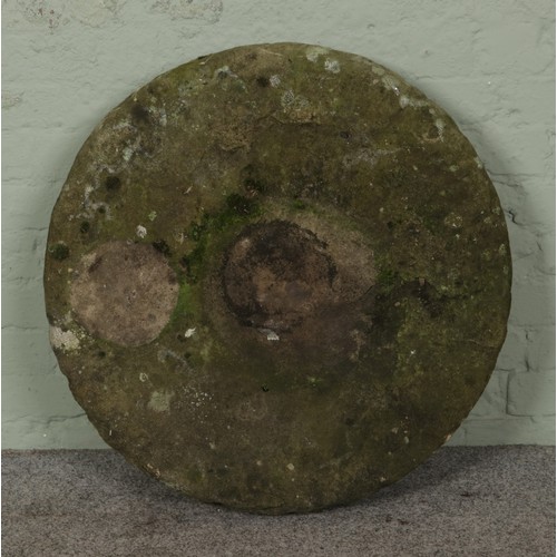 353 - A stone mill wheel/circular plinth. Diameter: 74cm.