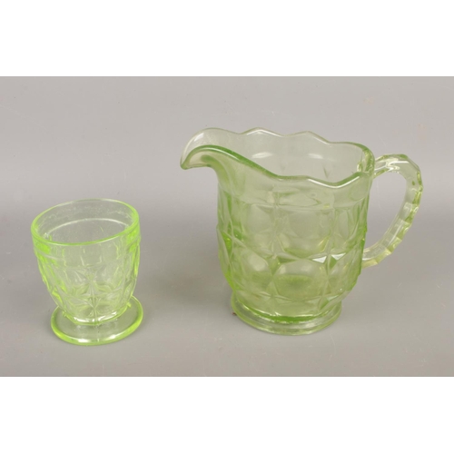 16 - A collection of assorted glassware, including uranium jug and cup, along with art glass pots and vas... 