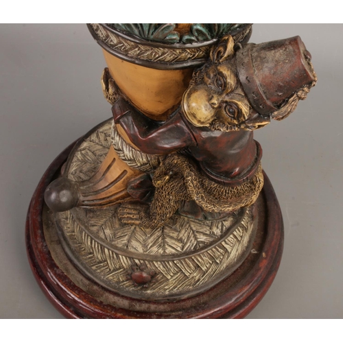 56 - A vintage composite monkey butler vase on wooden base, size H34 x W20cm including the base.