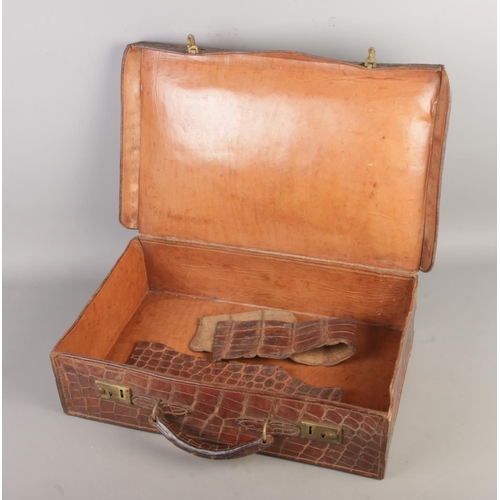 60 - An early 20th century crocodile skin suitcase, size W47 x D32 x H13cm.