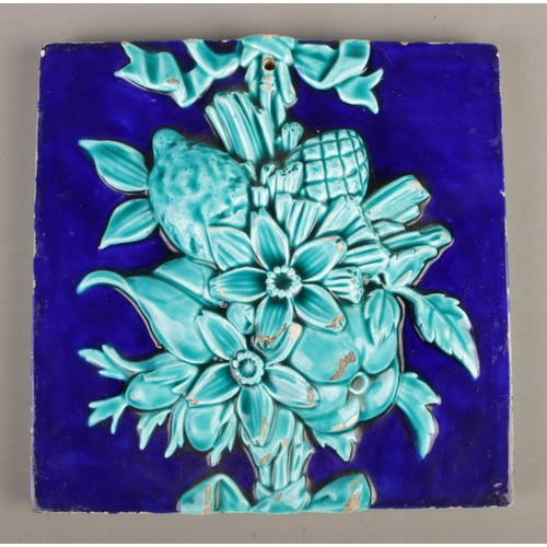 61 - A large Mintons deep blue and turquoise tile with raised floral and fruit decoration. Stamped Minton... 