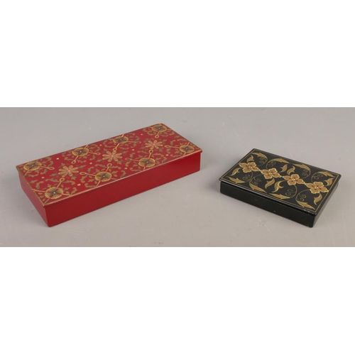 63 - Two painted lacquered boxes. Featuring gilt floral decoration to the hinged tops. Largest: Width: 23... 