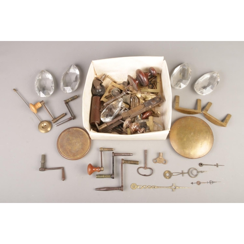 72 - A box of assorted fixtures and fittings, mainly clock parts. To include winding handles and keys, gl... 