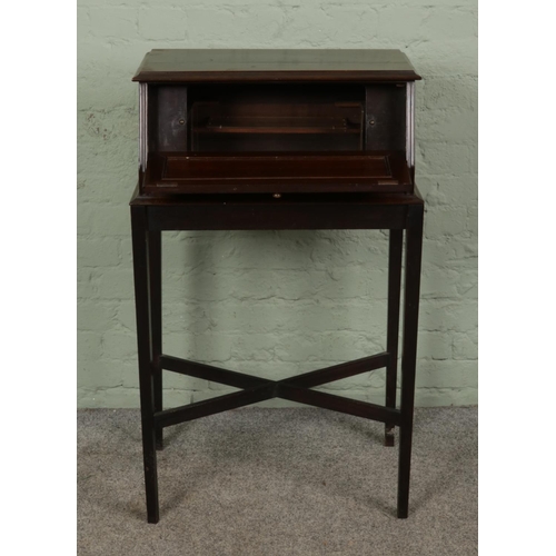 376 - A mahogany cabinet with drop down front, possibly originally housing a music box. Raised on tapering... 