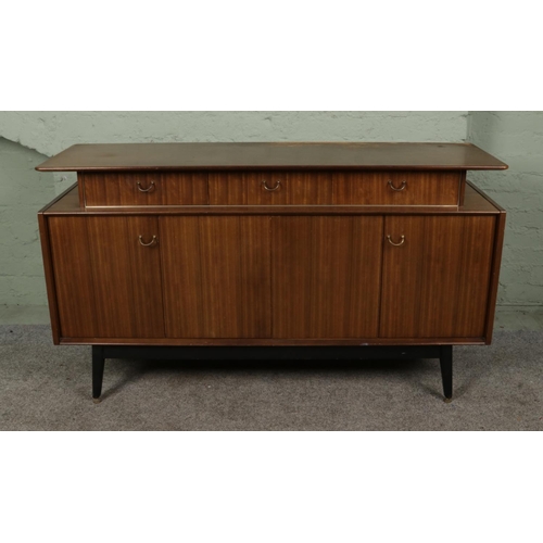 379 - A G-Plan E Gomme Librenza sideboard, c.1960's, having three drawers below a floating shelf above bif... 