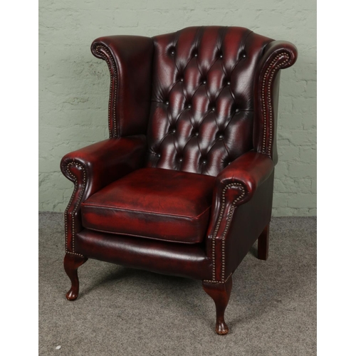 A deep buttoned and studded Chesterfield Wingback armchair, in oxblood red leather.

Hx103cm
Wx90cm
Dx85cm