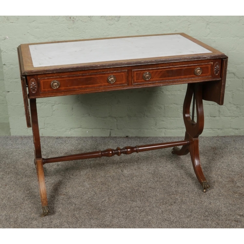 392 - A mahogany sofa table with leather inset top, brass feet and casters.

Hx74cm
Wx144cm (with sides pu... 