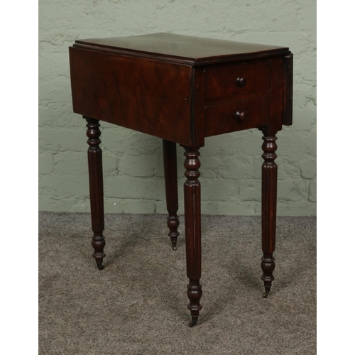 402 - A Victorian Pembroke table with two drawers to one side on reeded column legs and brass castors.

Hx... 