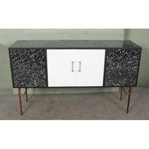 477 - A mid-century retro sideboard and matched rectangular table, with black marble effect surface and me... 