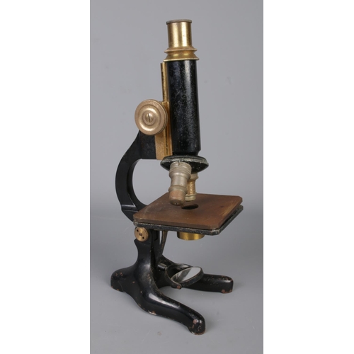 120 - A Philip Harris & Co. Ltd. of Birmingham microscope featuring brass adjustments.