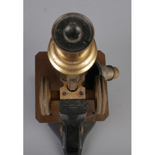 120 - A Philip Harris & Co. Ltd. of Birmingham microscope featuring brass adjustments.