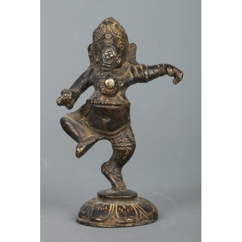 411 - A small bronze figure of the Hindu God Ganesha, raised on lotus flower base. Height: 9cm.