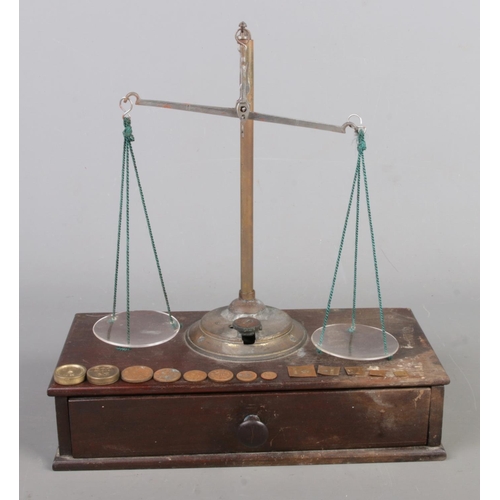 12 - An antique set of travelling Apothecary scales, with Drachm weights, wooden base and drawer. Size W2... 