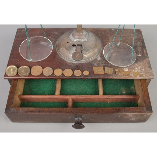 12 - An antique set of travelling Apothecary scales, with Drachm weights, wooden base and drawer. Size W2... 