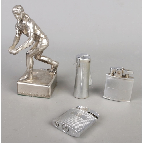 13 - Four vintage lighters, comprising three Ronson lighters and a Japanese white metal player statue lig... 