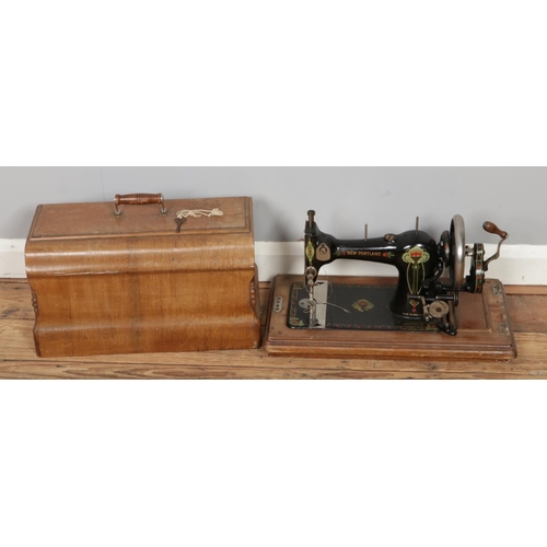 255 - Two artists easels with an antique cased New Portland sewing machine, serial No. 434274 with key.