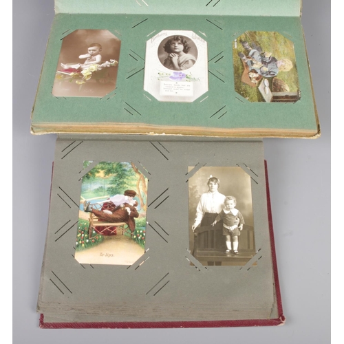 52 - Four antique photo albums, containing a selection of stamped photograph postcards, mostly portrait f... 