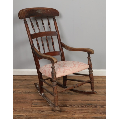 471 - An elm rocking chair with spindle back and padded seat.