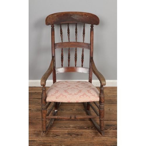 471 - An elm rocking chair with spindle back and padded seat.