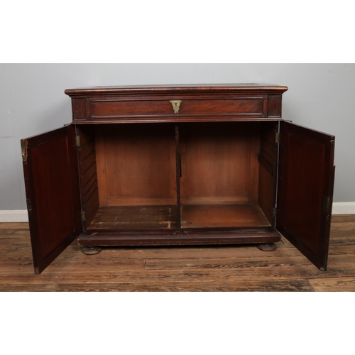 476 - A large mahogany bookcase base with two cupboard doors with columns to either side and singular draw... 