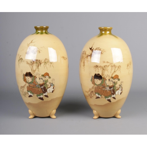 51 - A pair of oriental style vases depicting children playing on each vase. Hx32cm