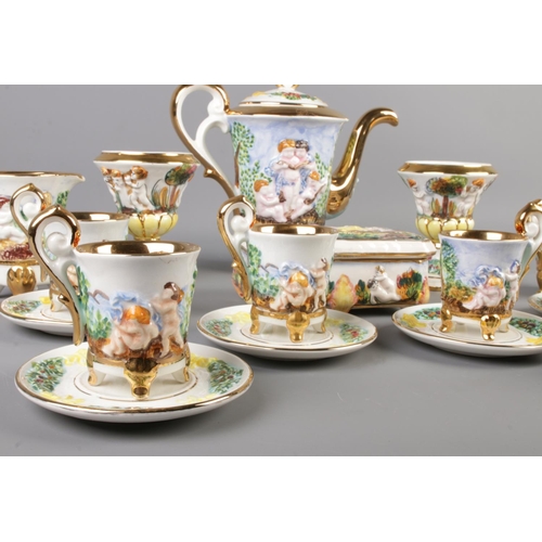 2 - A Capodimonte tea service featuring gilt edging and decorated with cherubs. Comprising of cups, sauc... 