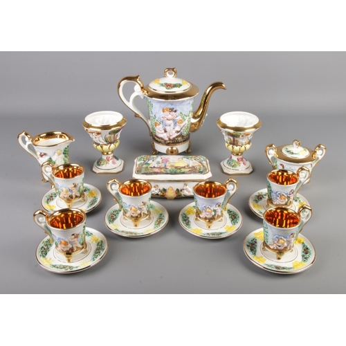 2 - A Capodimonte tea service featuring gilt edging and decorated with cherubs. Comprising of cups, sauc... 