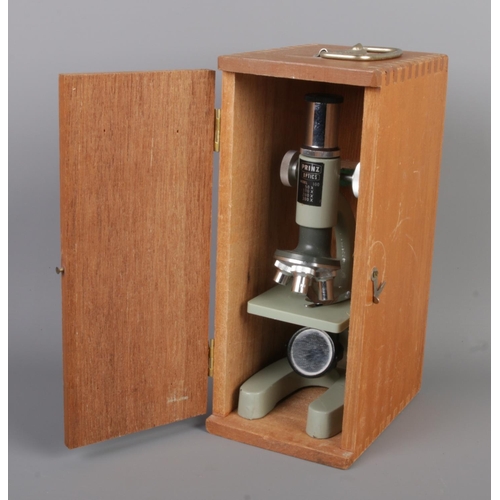 26 - A vintage Prinz Optics Model 100 microscope in wooden storage box.