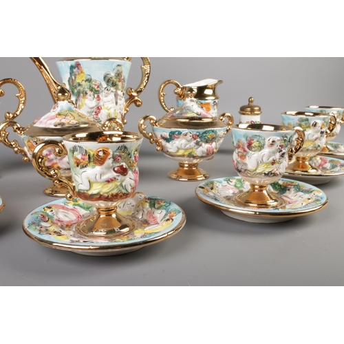 60 - A Capodimonte style tea service featuring gilt edging and decorated with cherubs. Comprising of cups... 