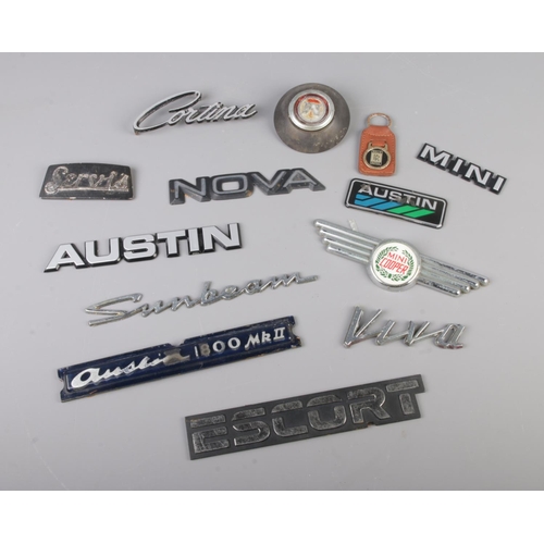 64 - A good collection of car badges including examples for Austin, Mini, Escort, Cortina, Sunbeam, Nova ... 