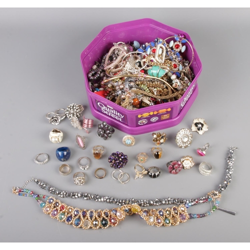 69 - A tub of assorted costume jewellery to include necklaces, bracelets and a large quantity of dress ri... 