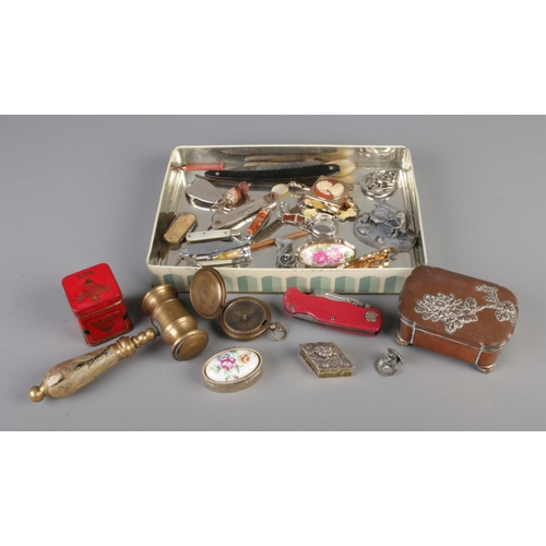 85 - A tin of mixed collectables including gavel, silver plate pill box, penknives, cameo pill box, razor... 