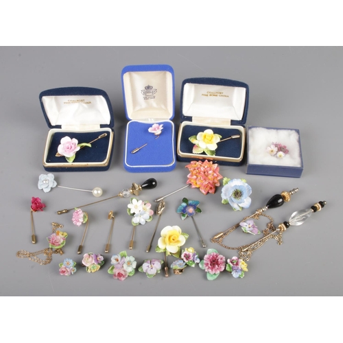 96 - A small tray of stick pins and brooches predominantly floral examples.