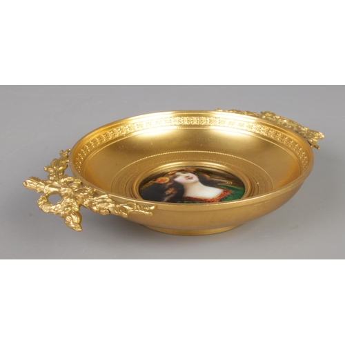 21 - A French gilt bronze twin handled dish. Having central enamelled plaque depicting a maiden, possibly... 