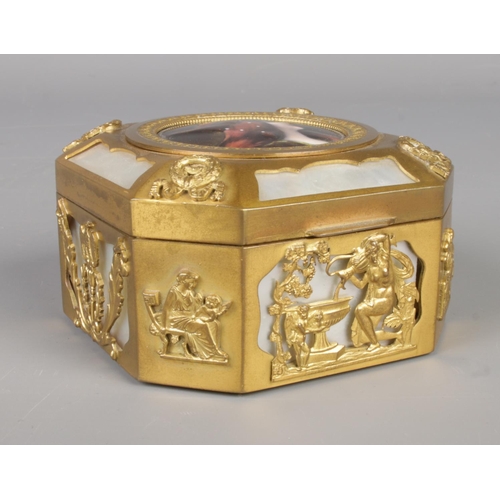 22 - A French gilt metal and mother of pearl box of cantered square form. Having classical scenes and cen... 