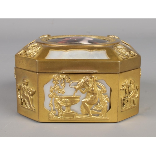 22 - A French gilt metal and mother of pearl box of cantered square form. Having classical scenes and cen... 