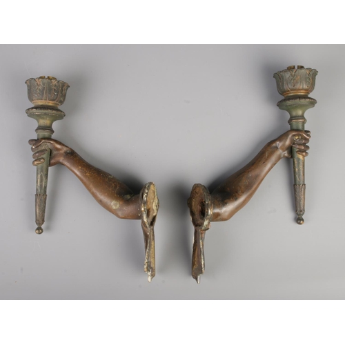 28 - A pair of bronze wall sconces modelled as outstretched arms holding torches. Height 31cm, Length 23c... 