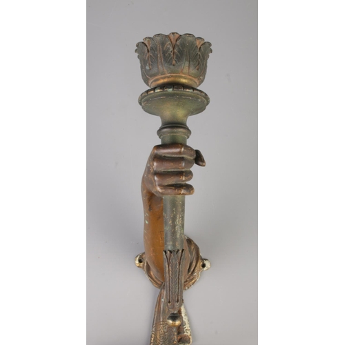 28 - A pair of bronze wall sconces modelled as outstretched arms holding torches. Height 31cm, Length 23c... 