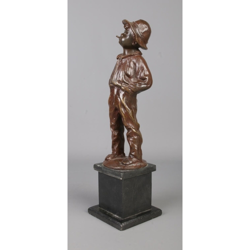 32 - A bronze sculpture of a young boy raised on a square slate plinth. Modelled smoking a cigar, stood w... 