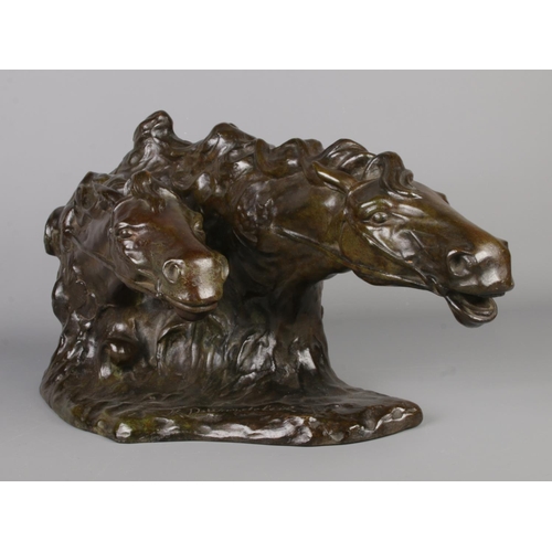 35 - A bronze sculpture modelled as two horses heads. Signed R De Wandeleir. Height 26cm, Length 50cm.