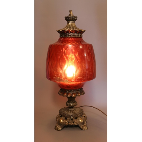 40 - A vintage brass lamp with large cranberry glass shade. Height 61cm.