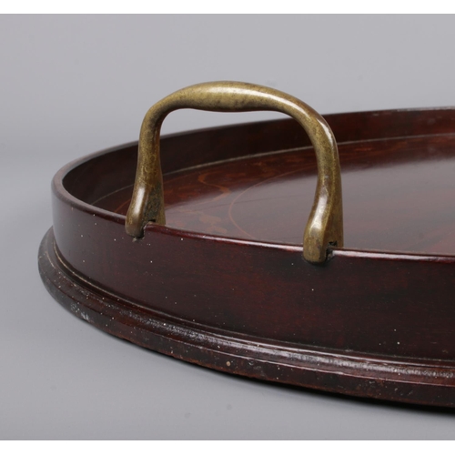 46 - A Victorian mahogany twin handled oval tray. With marquetry inlaid decoration. 49cm x 62cm.