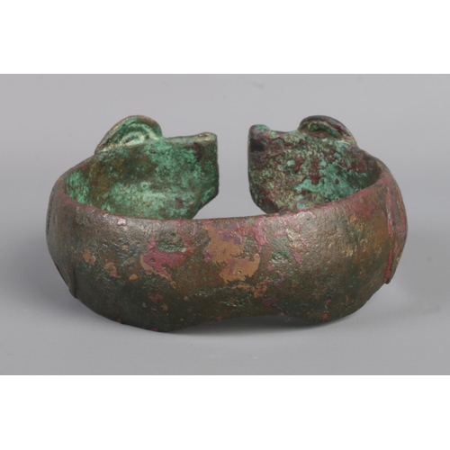 44 - A Greek Mycenaean (approximately 1500-1200BC) bronze penannular bracelet/armlet. Having ram head ter... 