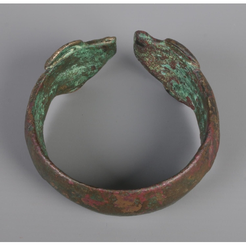 44 - A Greek Mycenaean (approximately 1500-1200BC) bronze penannular bracelet/armlet. Having ram head ter... 