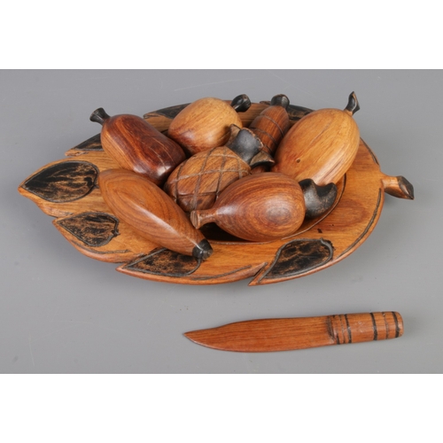 279 - A mid-century vintage hand-carved wooden fruit bowl containing eight pieces, bowl size 32x22cm.