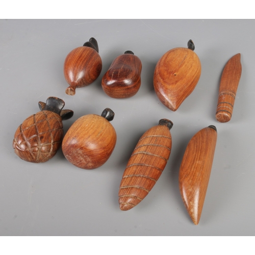 279 - A mid-century vintage hand-carved wooden fruit bowl containing eight pieces, bowl size 32x22cm.